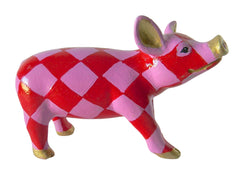 Hand-painted resin pig figurine with bold red and pink harlequin diamond pattern, accented with gold on the ears, snout, and hooves from the Painted Pigs collection.