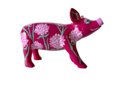 Hand-painted resin mini pig figurine with soft pink hydrangea flowers and green stems on a bold magenta base, featuring floral and botanical detailing.