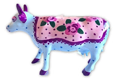 Hand-painted resin mini cow with a baby-blue body, purple accents, and a pink floral blanket featuring roses and polka dots—part of The Painted Pigs collection.