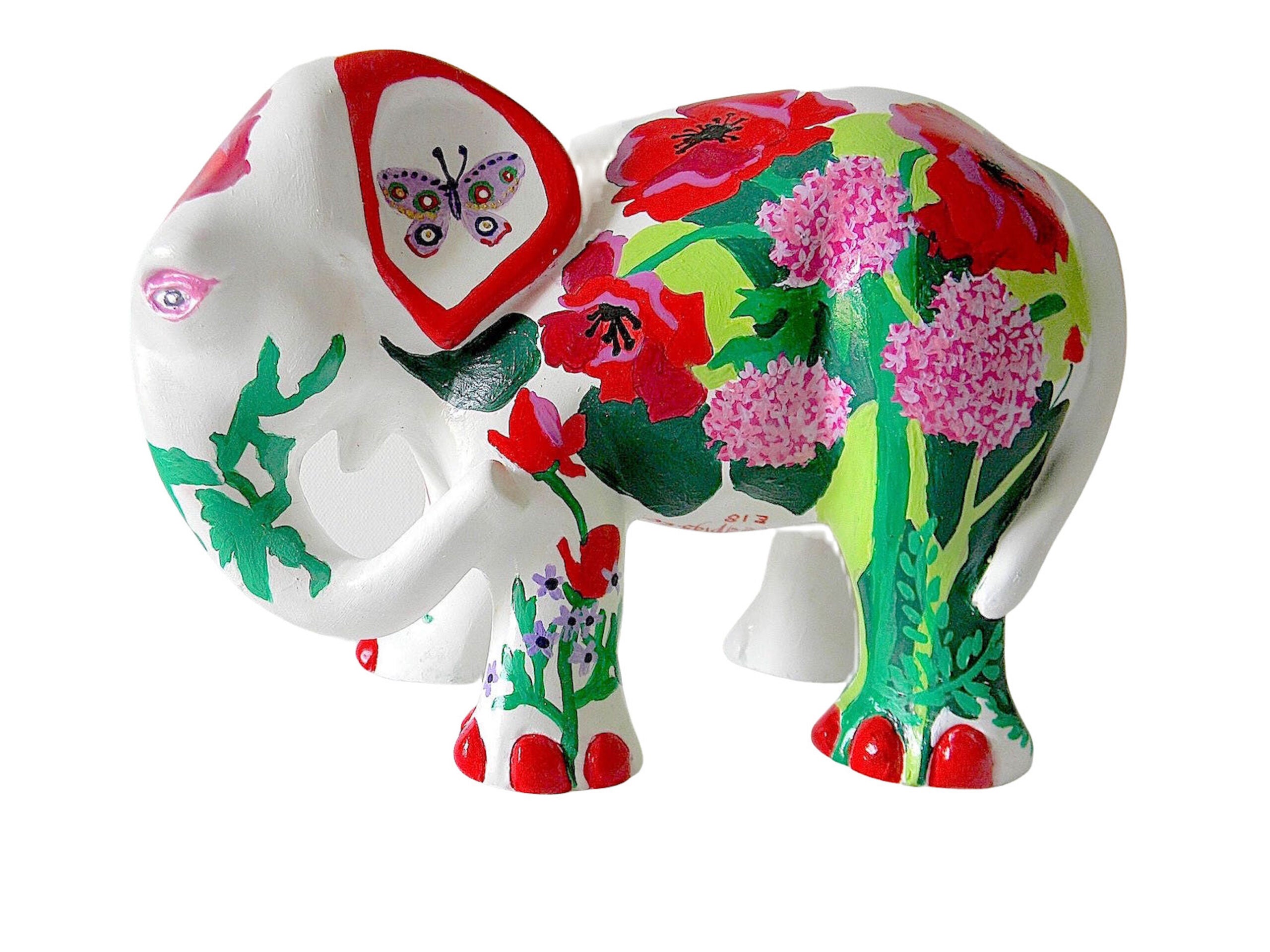 Hand-painted resin elephant figurine with red and pink floral designs, green leafy details, and a whimsical butterfly accent on a white base.
