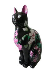 Handmade black resin large cat with hand-painted floral design featuring pink, white, and purple blossoms with green leaves on a glossy finish.