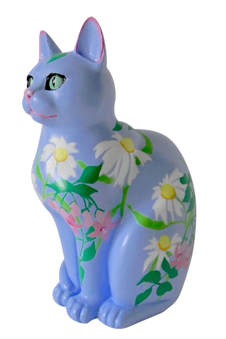 Hand-painted resin cat figurine with a periwinkle blue base, featuring white daisies, pink blossoms, and green foliage in a spring-inspired floral design