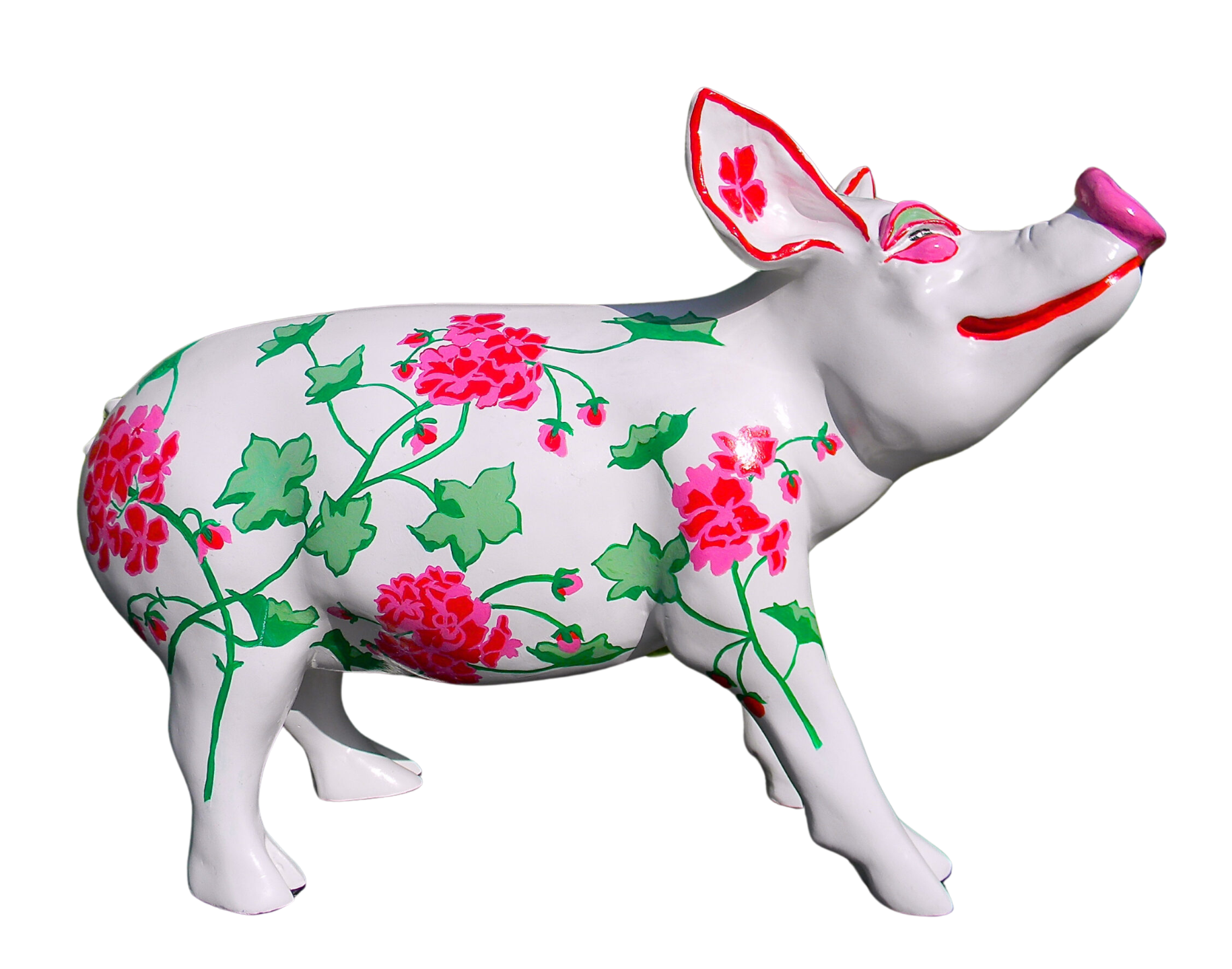 White hand-painted resin pig figurine decorated with pink geranium flowers and green leaves, dis-played outdoors against a leafy garden backdrop.